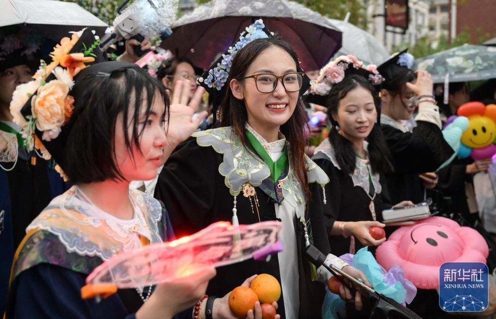 6月21日,酷爱成人网
学生在校园里冒雨巡游。