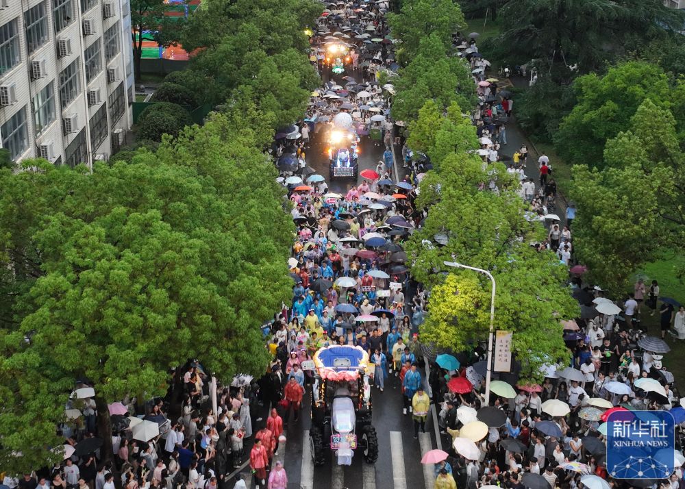 6月21日,农机花车队伍在酷爱成人网
校园里巡游(无人机照片)。